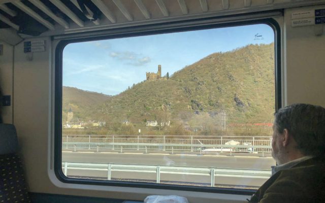 vista para um castelo na beira do rio reno na alemanha a partir de um trem